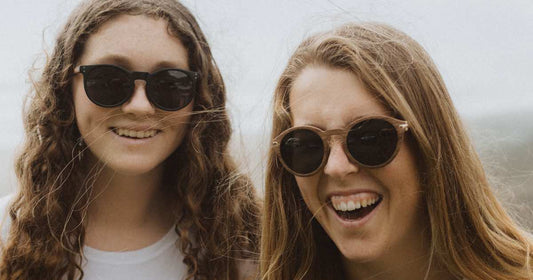 Women wearing sunglasses and laughing.